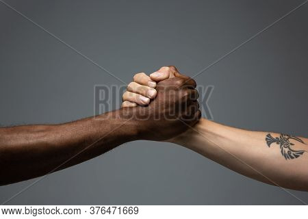 Teamwork. Racial Tolerance. Respect Social Unity. African And Caucasian Hands Gesturing On Gray Stud