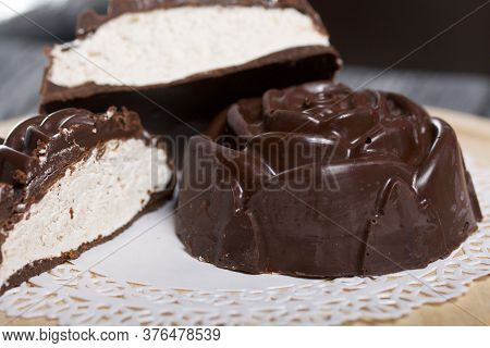 A Chocolate Marshmallow Made In The Shape Of A Rose Lies On A White Napkin. One Marshmallow Is Cut I