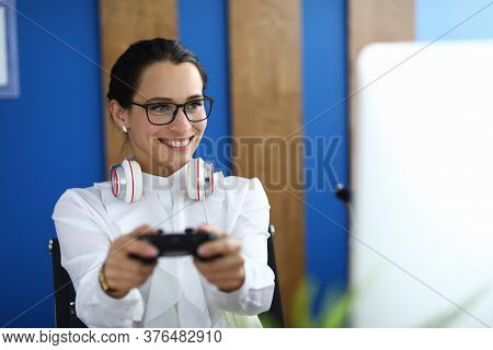 Portrait Of Cheerful Young Woman Playing Video Game With Headset On Neck. Happy Pretty Female Relaxi