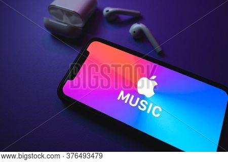 Apple Music Logo On The Smartphone Screen, With Airpods. High Quality Photo