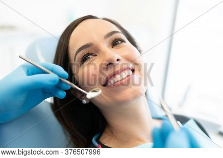 Dentist Checking Caucasian Woman With Carver And Mirror At Dental Clinic