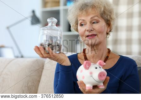 Portrait Of Senior Attractive Woman Holding Pink Piggy-bank. Elderly Female And Glass Container For 