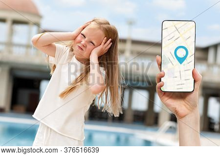 Online Navigation.a Girl Holding Her Head With Her Hands, Lost In The Street.in The Background, A Wo