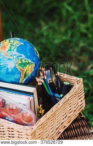 Back To School - School Equipment, Books And Globe With Ukrainian Signature In The Basket. Soft Focu