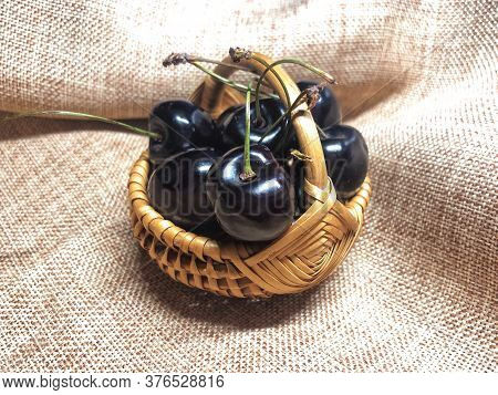 Dark Red Sweet Cherries In Mini Basket On Crunched Linen Fabric Background, Concept Of Healthy Shopp