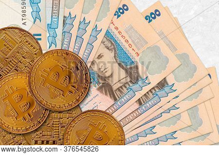 200 Ukrainian Hryvnias Bills And Golden Bitcoins. Cryptocurrency Investment Concept. Crypto Mining O