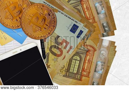 50 Euro Bills And Golden Bitcoins With Smartphone And Credit Cards. Cryptocurrency Investment Concep