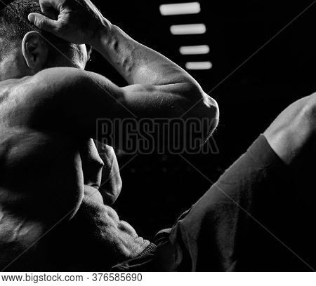 Black And White Crop Of Muscular Caucasian Man Training Abs On Mat In Gym. Side View Of Incognito Sp