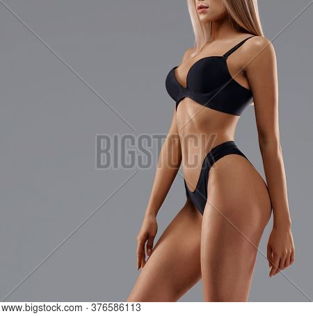 Side Crop Of Incognito Sexy Caucasian Female Model Wearing Black Lingerie Standing, Isolated On Grey