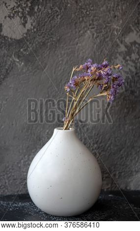 Dryflower In A White Vase Standing On A Black Table
