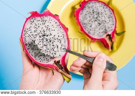 Pitaya Is The Fruit Of The Dragon. The Girl Is Eating A Tropical Fruit With A Spoon. Sweet Pitaya On