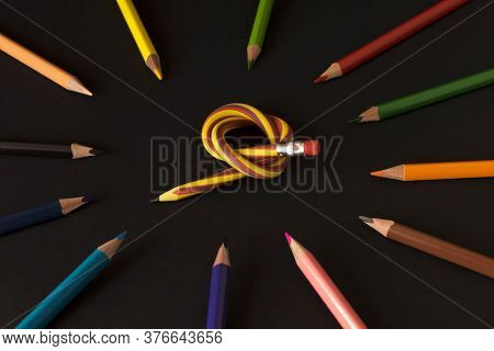Flexible Pencil And A Set Of Colored Pencils On A Dark Background. Selective Focus