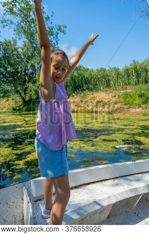 Beautiful Little Girl With Her Hair Up And Dressed In Pastel Colors Posing Fun Riding On A White Boa