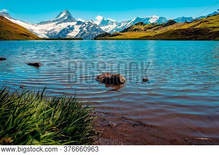 Picturesque View Of Mountain Lake Bachalpsee With The Snow Capped Peaks Of Wetterhorn, Schreckhorn A