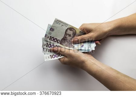 Female Hands Holds A Five Thousand Hryvnia. Ukrainian Currency With Woman's Hands Against A White Ba
