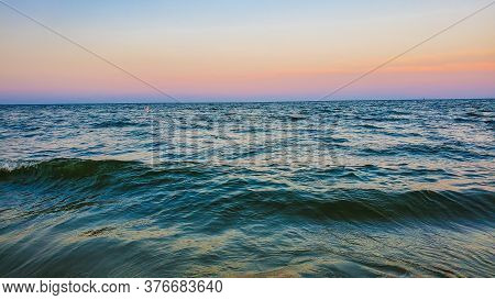 Sunset At The Beach. Small Waves Coming In.