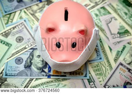 Piggy Bank In A Mask On A Background Of American Currency.the Concept Of Coronavrius Epidemic