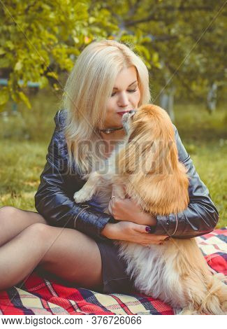 Middle Age Stylish Blonde Hair Pretty Woman Dressed In Leather Black Jacket  In Autumn Garden With P
