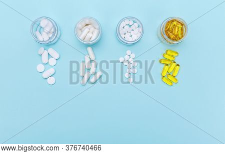 Four Packages With Various White Pills And Capcules On A White Background. Health Concept. Copy Spac