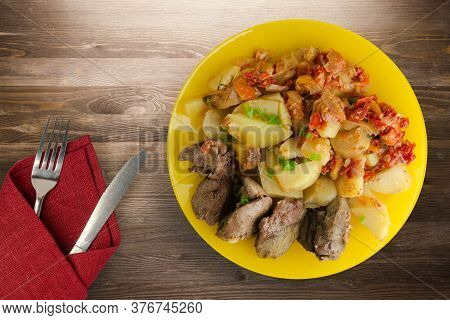 Fried Liver With Potatoes And Stewed Tomatoes With Fork And Knige. Fried Liver On Yellow Plate On Br