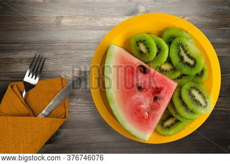 Watermelon And Kiwi Sliced On A Yellow Plate Or A Black Wooden Background .watermelon And Kiw With F