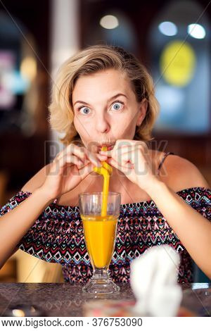 A Worker Measuring Temperature Of Woman Visitior Inside  Of The Cafe. Life During Coronavirus Time