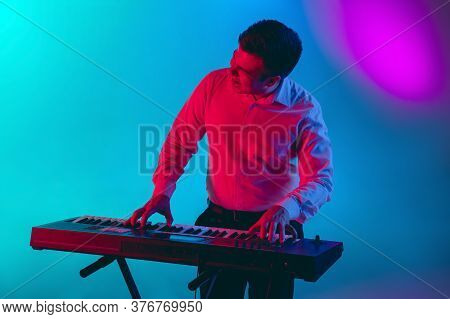 Rhytm Accent. Young Caucasian Inspired And Expressive Musician, Keyboardist Performing On Multicolor
