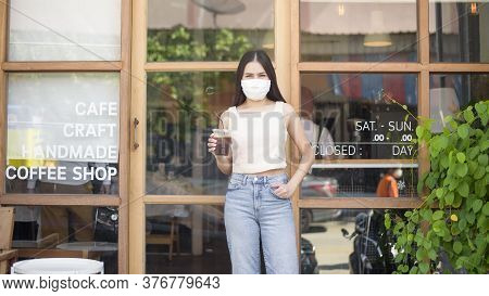 Beautiful Woman With Face Mask Is Holding Coffee In Front Of Coffee Shop
