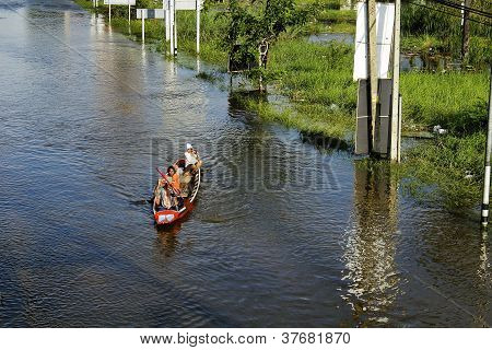 Unidentified people have to travel by boat on the road during flood