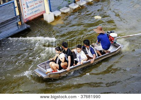 Unidentified people have to travel by boat on the road during flood