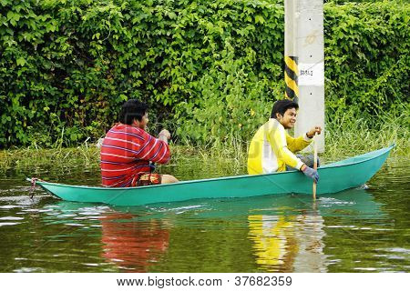 Unidentified people have to travel by boat on the road during flood