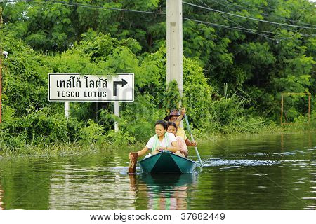 Unidentified people have to travel by boat on the road during flood