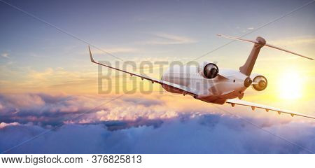 Private jetplane flying above clouds, front cabin view. Sunset light
