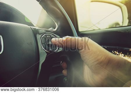 Driver Hand Pressing To Adaptive Cruise Control  Button On Steering Wheel Of A Car