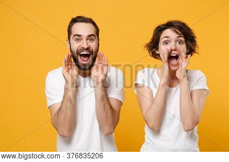 Cheerful Young Couple Friends Bearded Guy Girl In White Blank T-shirts Posing Isolated On Yellow Ora