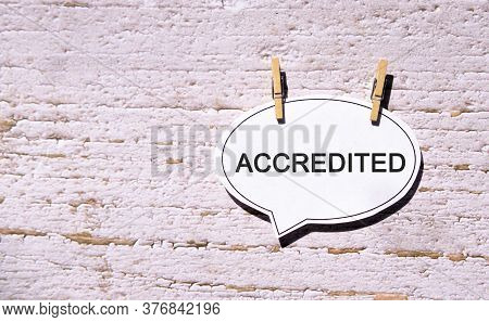 Accredited On A White Sheet With Wooden Pins
