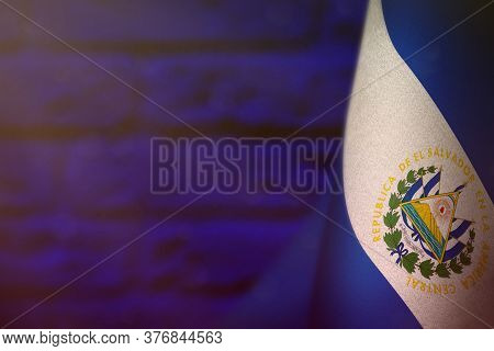 El Salvador Hanging Flag For Honour Of Veterans Day Or Memorial Day On Blue Blurred Painted Brick Wa