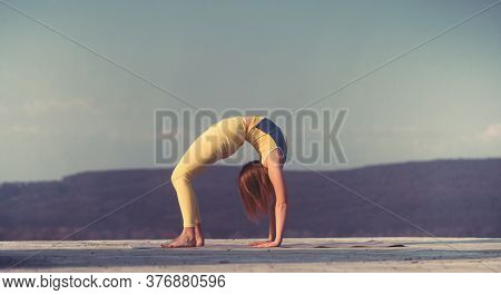 Young Gymnast Girl Perform Various Gymnastic And Yoga Exercises, Including Splits And Bending Over B