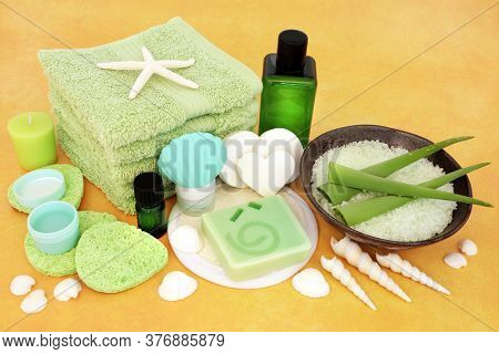 Natural skincare beauty treatment for anti ageing with aloe vera & ex foliation, moisturiser, aromatherapy &  cleansing products on yellow background.