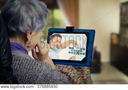 The Telemedicine Dentist Tells The Elderly Patient The Result Of The X-ray Of All Her Teeth. The Sen