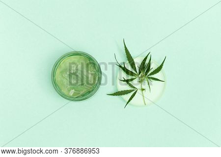 Jar With Transparent Cosmetic Product, Gel Or Cream With Cannabis Oil On Blue Colored Background. Fl