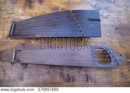 Wooden Psaltery On A Table Of Brown Boards. Folk Wooden Musical Instruments Leisure Hobbies.