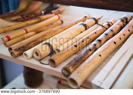 Flute Hornpipe In Front Of A White Board. Selective Focus. Folk Wooden Musical Instruments Leisure H