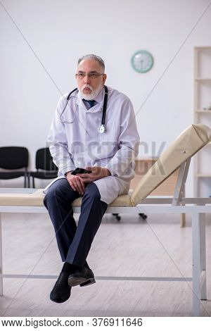 Old male doctor working in the clinic