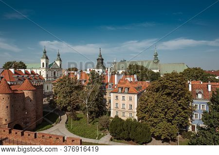 Warsaw, Poland Summer View Of Barbican Or Barbakan Wall And Old Town Houses With Green Trees And Blu