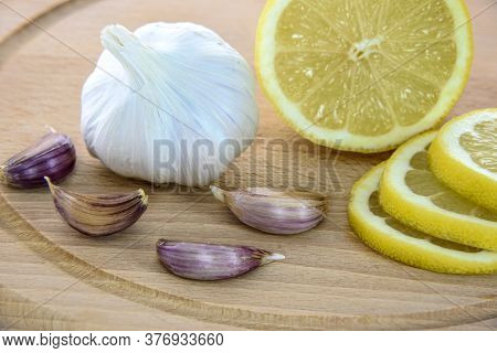Lemon Fruit With Pieces And Garlic Buds On Table