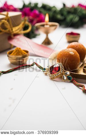 Indian Festival Raksha Bandhan With Rakhi Bracelets, Presents, Rice And Kumkum And Sweets In Plate