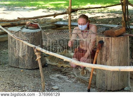 Virginia, U.s.a - July 1, 2020 - A Man Sewing And Knitting The Fishing Net While Wearing A Mask