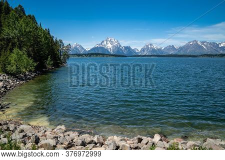 Shores Of Jackson Lake, Near The Jackson Lake Dam In Grand Teton National Park On A Sunny Summer Day