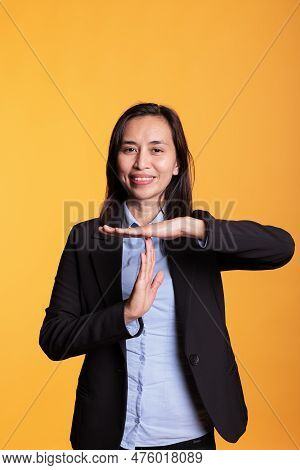 Cheerful Positive Model Doing Timeout Symbol With Hands, Expressing Half Time And Break In Studio Ov